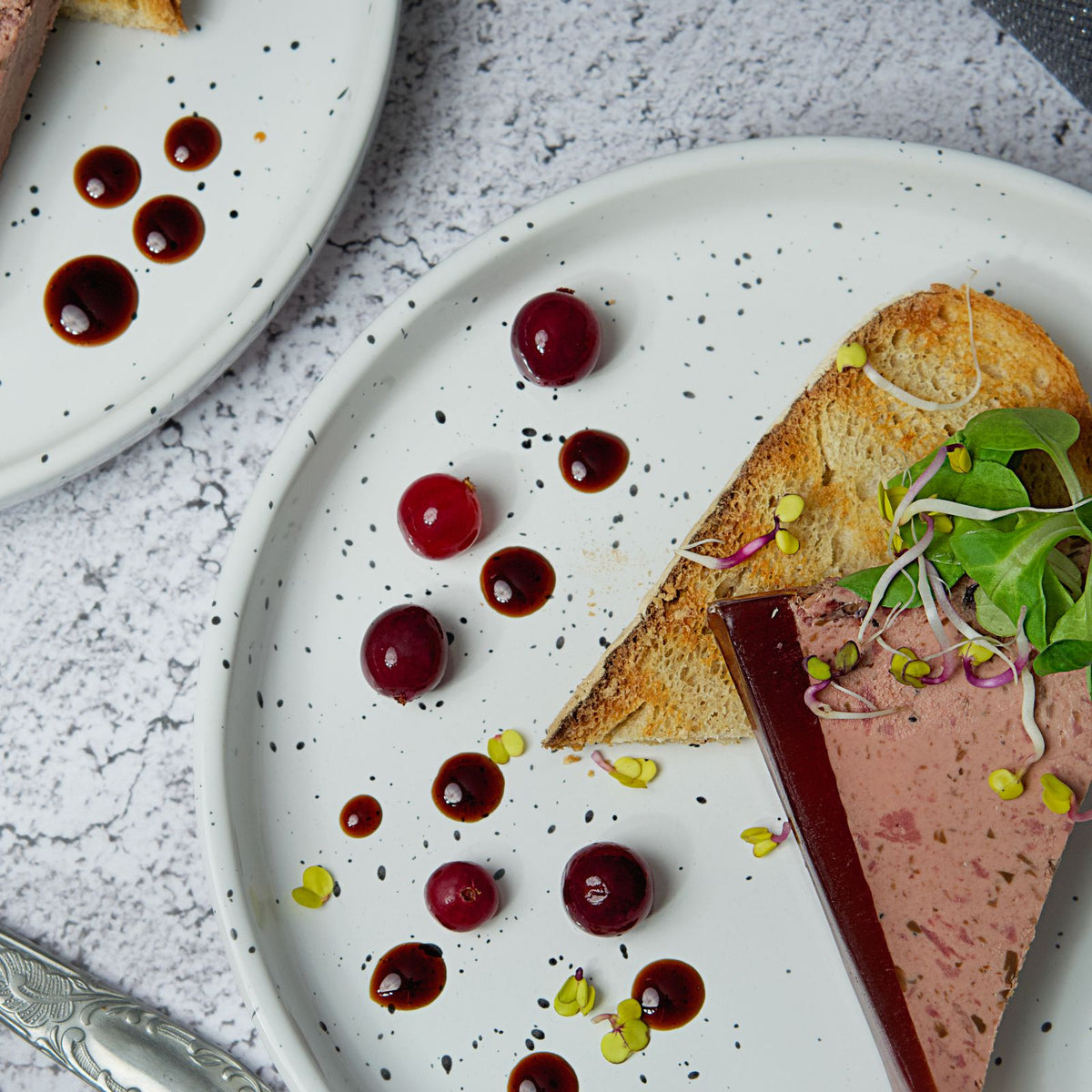 Tranche de foie gras servie avec pain grillé et canneberges